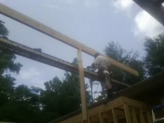 Carpenter setting a ridge beam over a new addition frame — Ice Dam Removal by Roofing Brothers in Westbrook