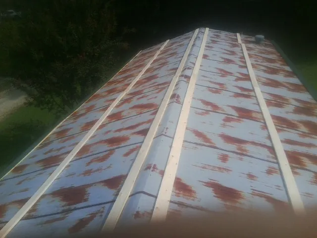 Rusted metal roof panels with new wood purlins before replacement — Storm Damage Roof Repair in Westbrook by Roofing Brothers