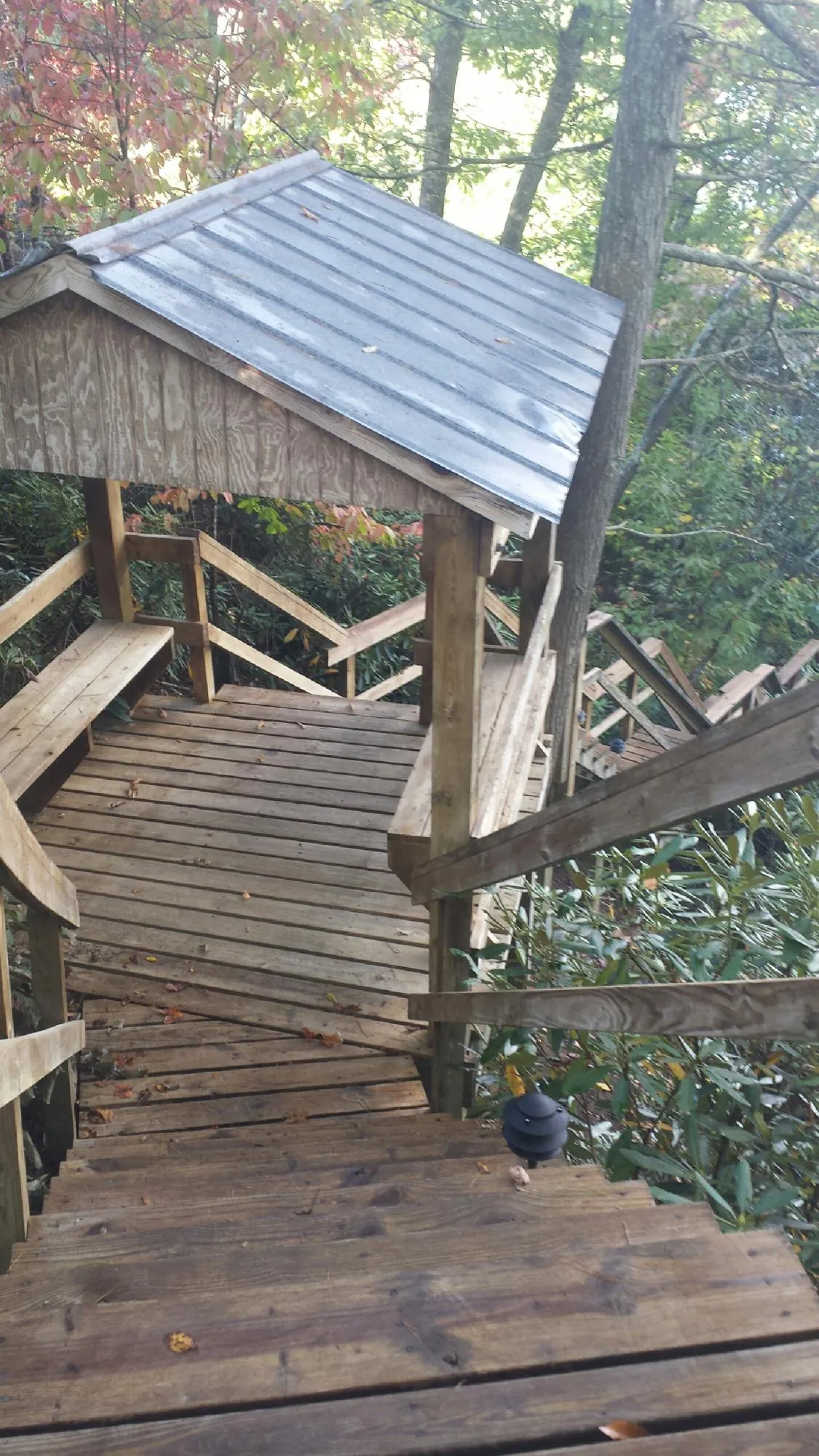 Metal roofed shelter over wooden steps on a wooded walkway — Skylight Repair & Installation work by our crew in Westbrook