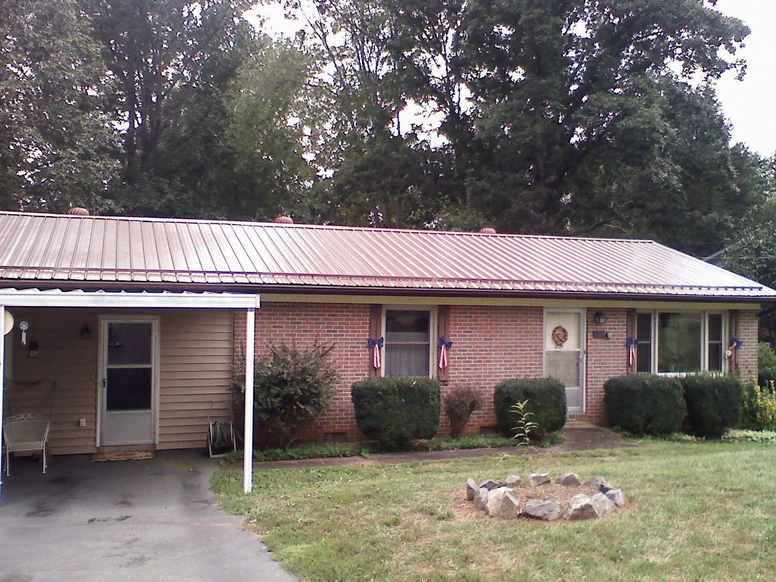 Bronze metal roof and carport on a brick ranch home — Roof Repair work by our crew in Westbrook